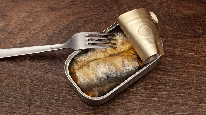 open can of sardines with fork