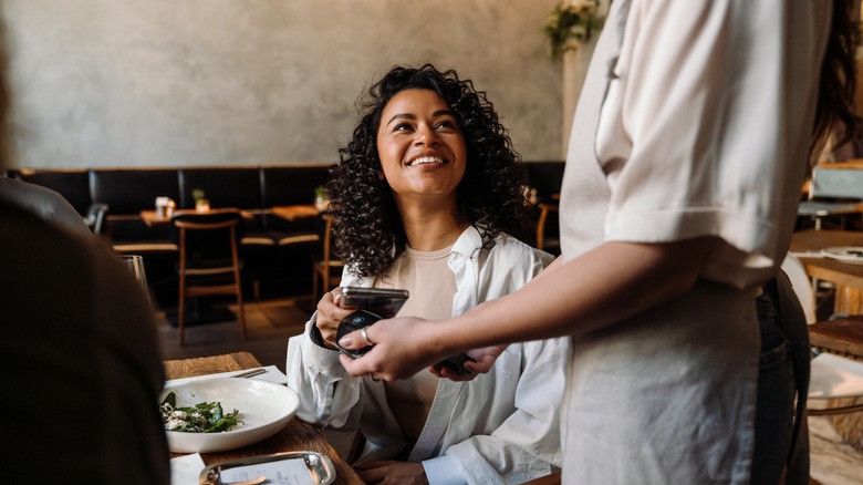 woman paying at restaurant