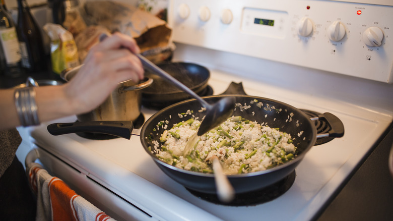 Person making risotto on a stovetop