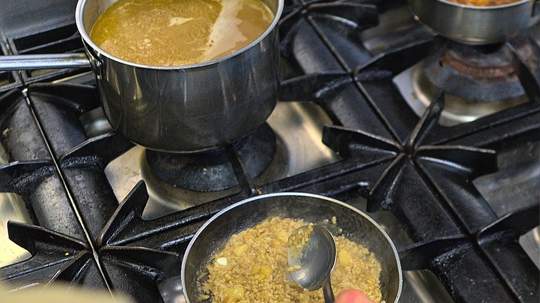 Making risotto next to broth on stove