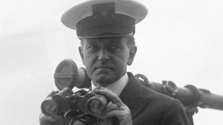 Calvin Coolidge holding binoculars