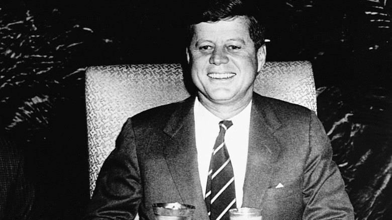 John F. Kennedy sits at formal dining table