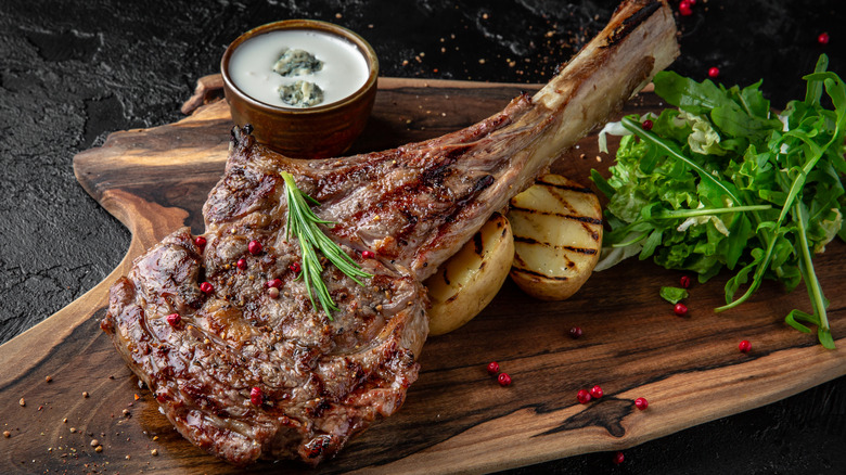 seared bone-in ribeye on wooden board