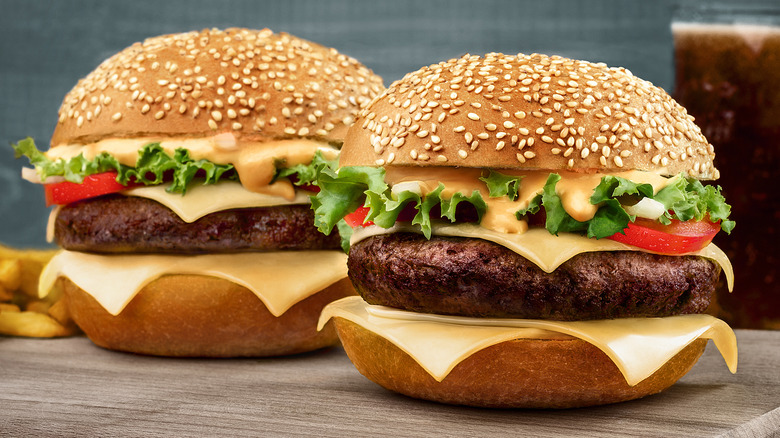 two cheeseburgers on sesame seed buns