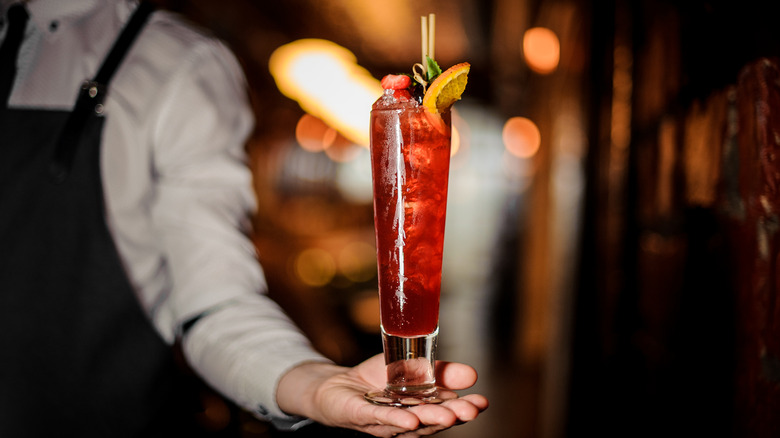 bartender holding fruity cocktail