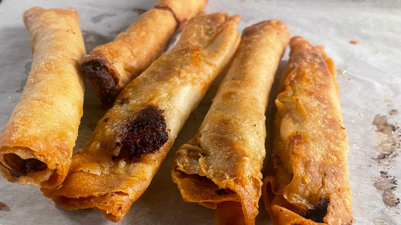 Oven-baked chicken taquitos on parchment paper