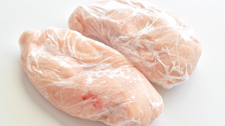 Plastic-wrapped frozen chicken meat