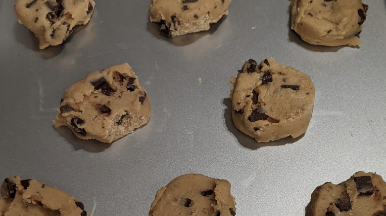 Cookie sheet with frozen chocolate chip cookie dough portions