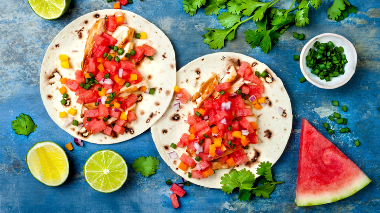 Tacos with watermelon salsa on blue table