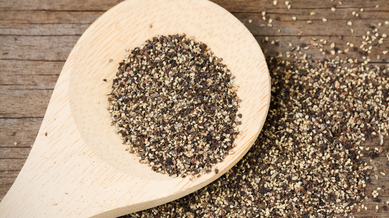 ground pepper with wooden spoon