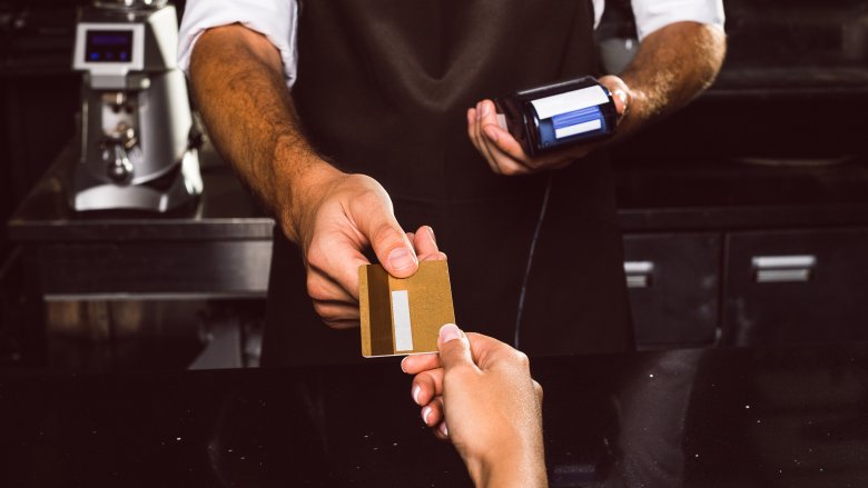 Woman paying with credit card at restaurant