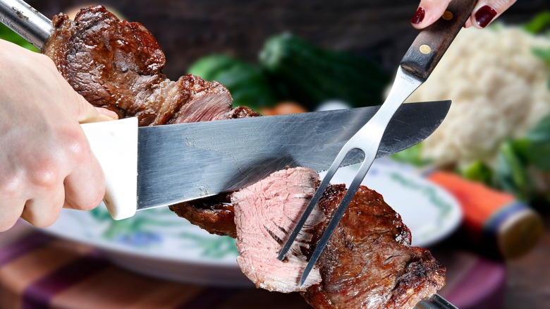 waiter serving meat off skewer