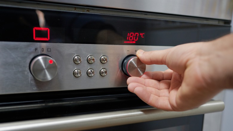 hand preheating an oven