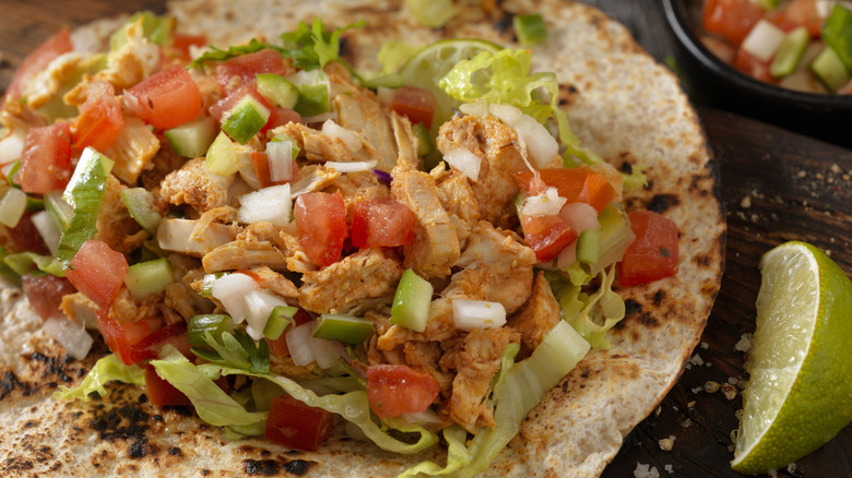 Chicken taco with salsa and lime wedge