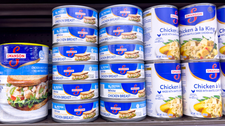 Cans of Swanson canned chicken on grocery store shelf