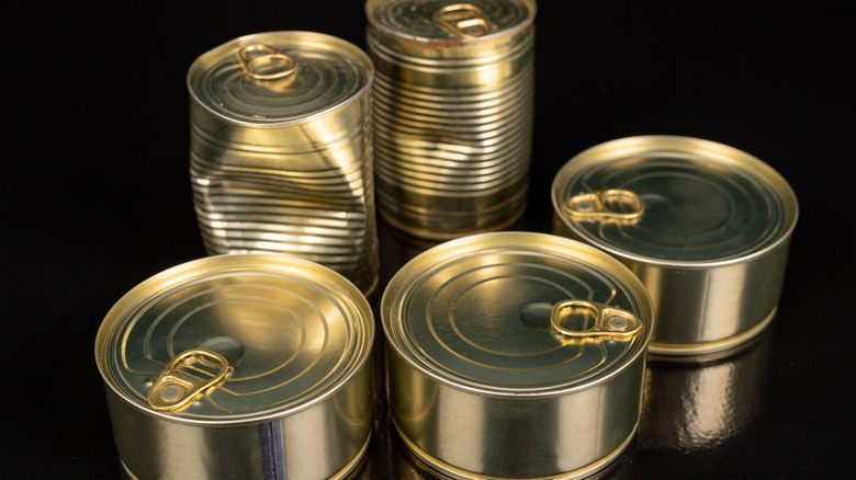 metal cans, two of which are dented
