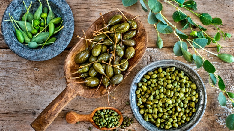 capers and caperberries in bowls and scoops