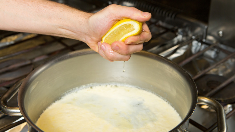 squeezing lemon into creamy sauce