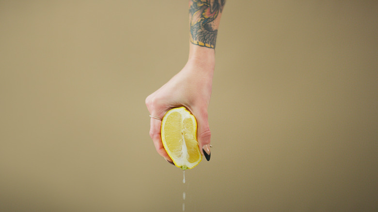 hand squeezing a lemon