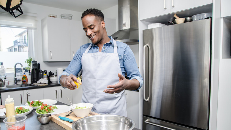 man squeezing lemon over food