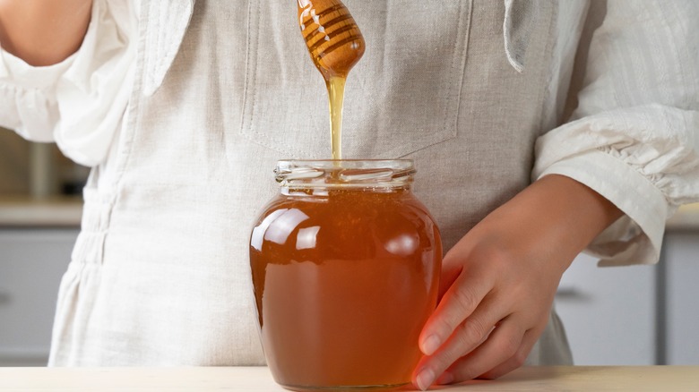 Honey dripping in a jar