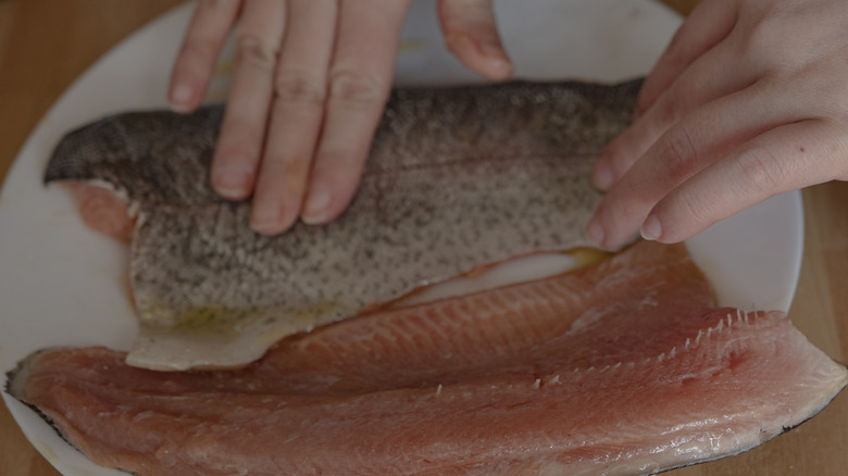 hands working with filets of fish