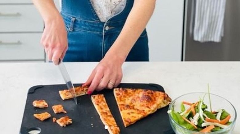 woman cutting pizza croutons