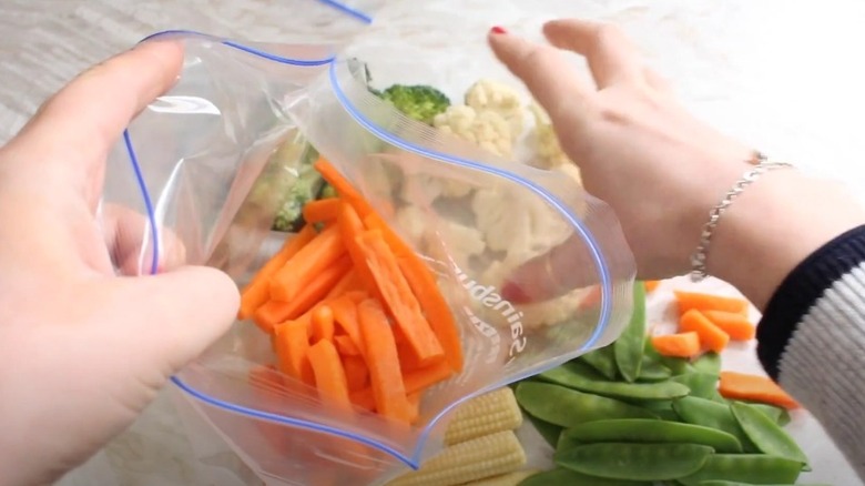 putting chopped vegetables into sandwich bag