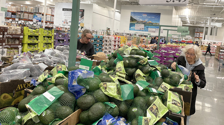 Shoppers examining avocados at a Costco warehouse