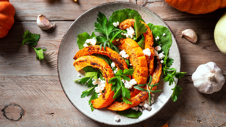 Salad with squash and feta on wooden table