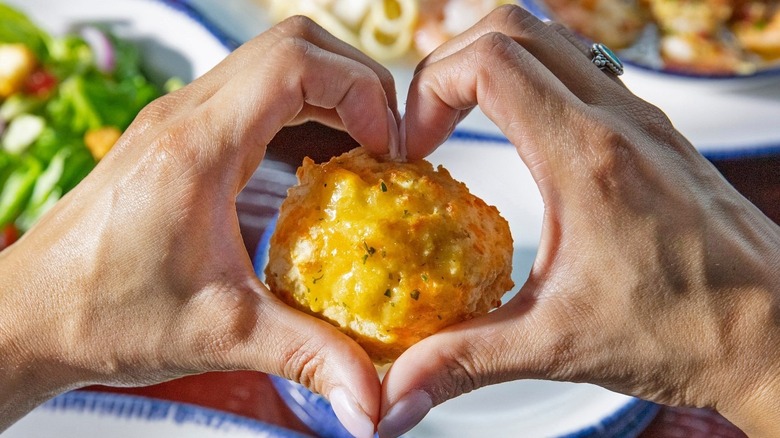 Hands holding a Cheddar Bay Biscuit