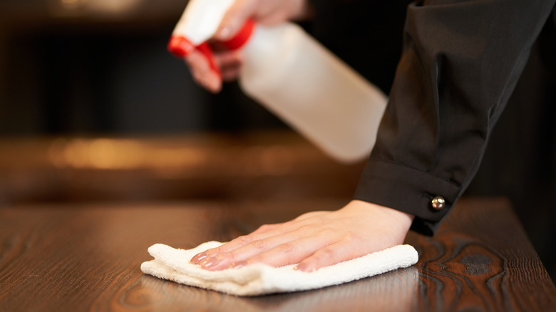 Worker wiping down wooden table