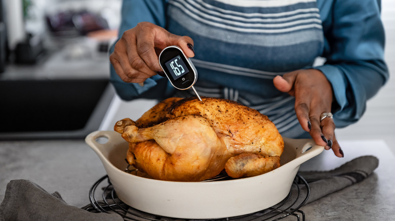 woman making turkey with digital thermometer