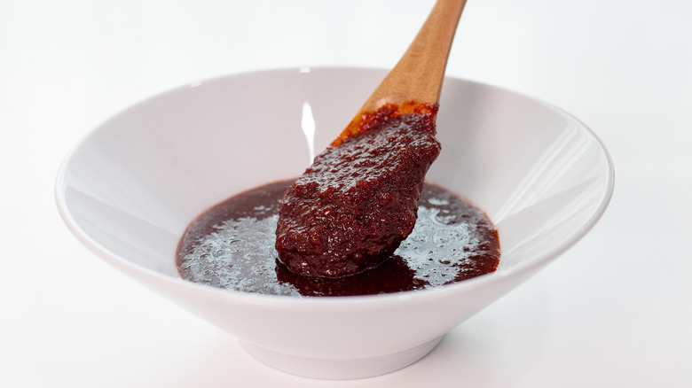 Bowl of gochujang with a wooden spoon