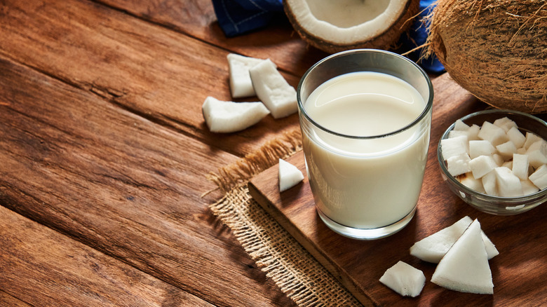 Glass of coconut milk and chunks of coconut