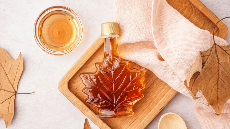 Bottle of maple syrup and maple leaves