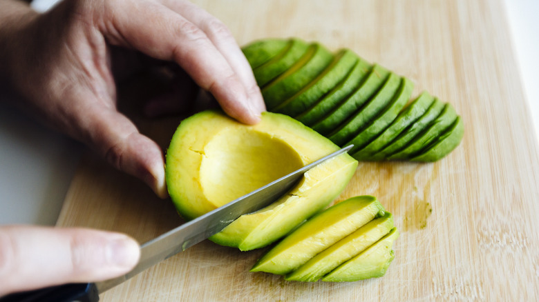 person slicing avocado