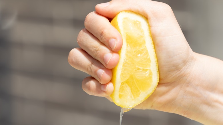 hand squeezing lemon