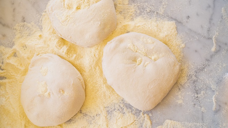 balls of pizza dough and semolina flour