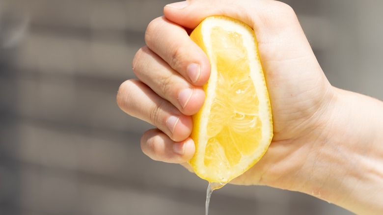 hand squeezing lemon