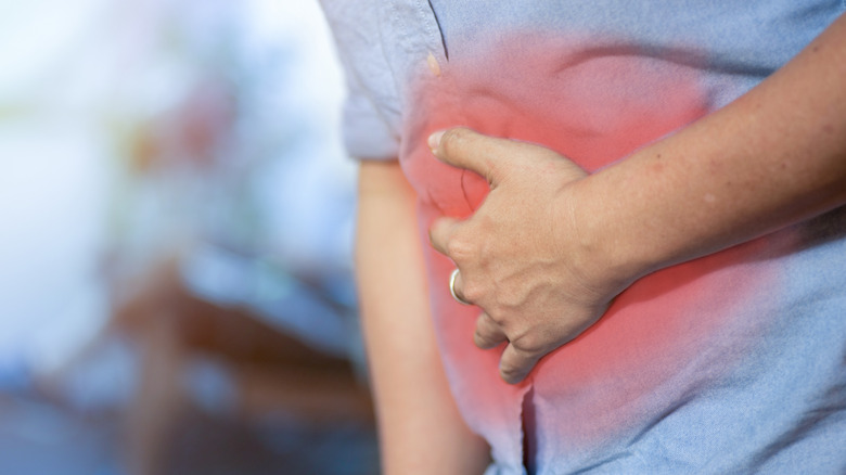 person clutching stomach in pain