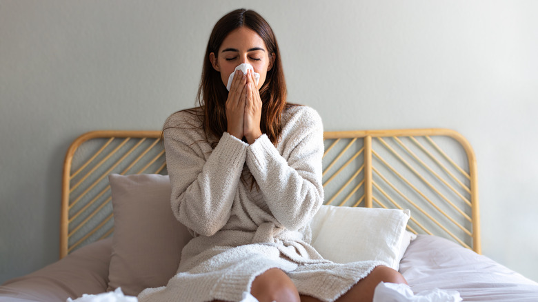 woman blowing nose into tissue