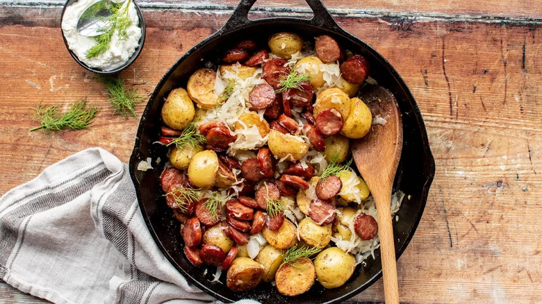 Potatoes, sauerkraut, and sausage in skillet with sour cream and dill