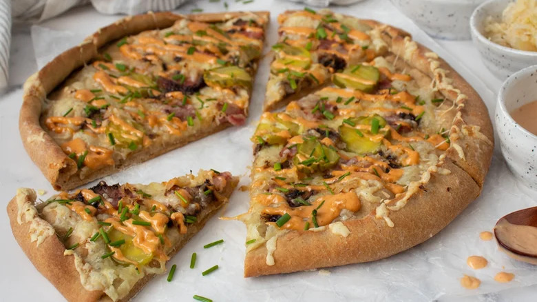 Pizza with sauerkraut, meat, and dill pickles with dressing