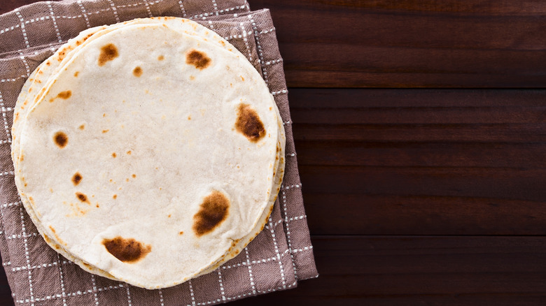 stack of tortillas on dish towel