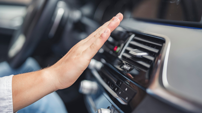 hand in front of car air conditioner