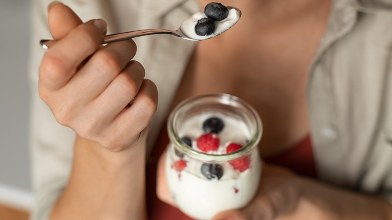 Woman eating yogurt with berries