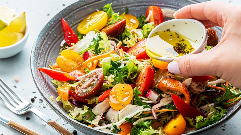 green salad adding dressing