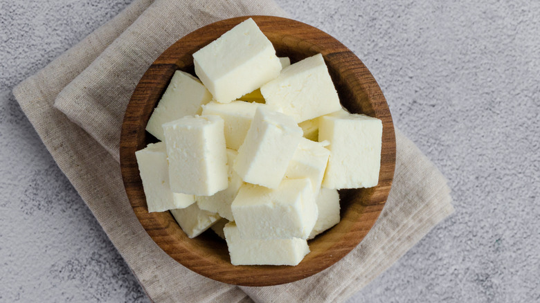 cubes of feta cheese in a small wood bowl