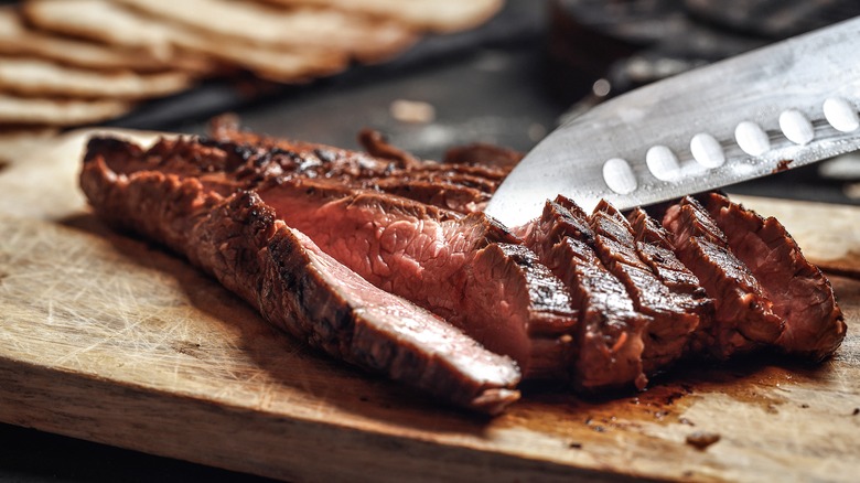 A steak cut in strips with a knife.